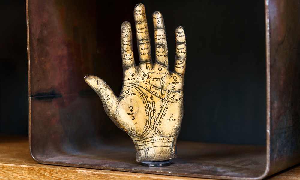 a gold colored hand model showing the lines and mounts of the palms and fingers
