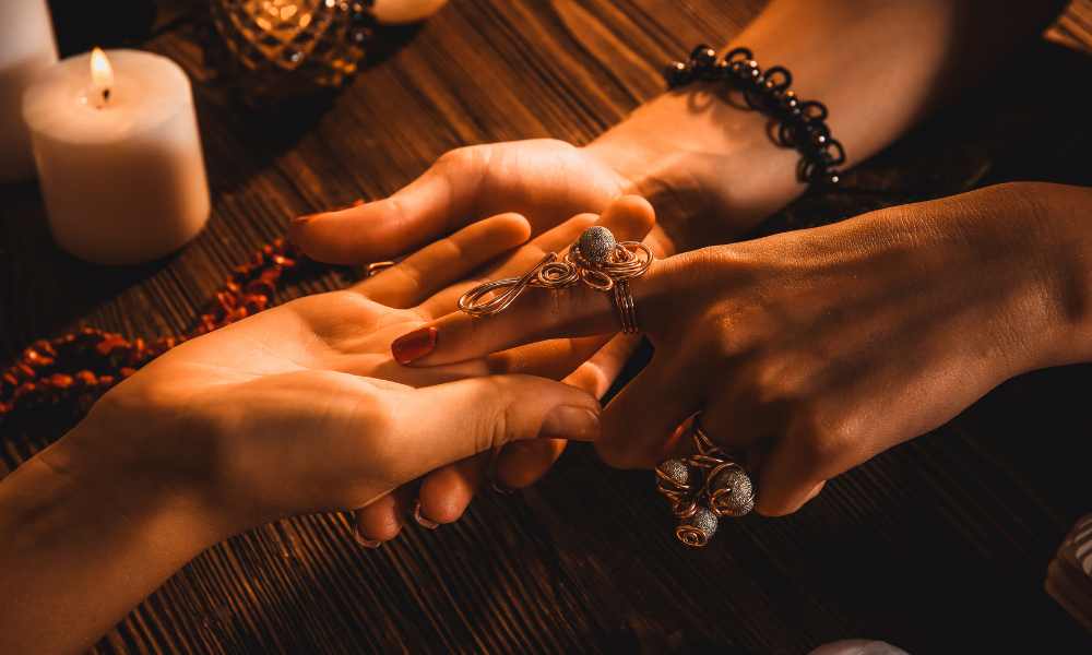 a palmist using her finger to point to the mount of Jupiter during a reading