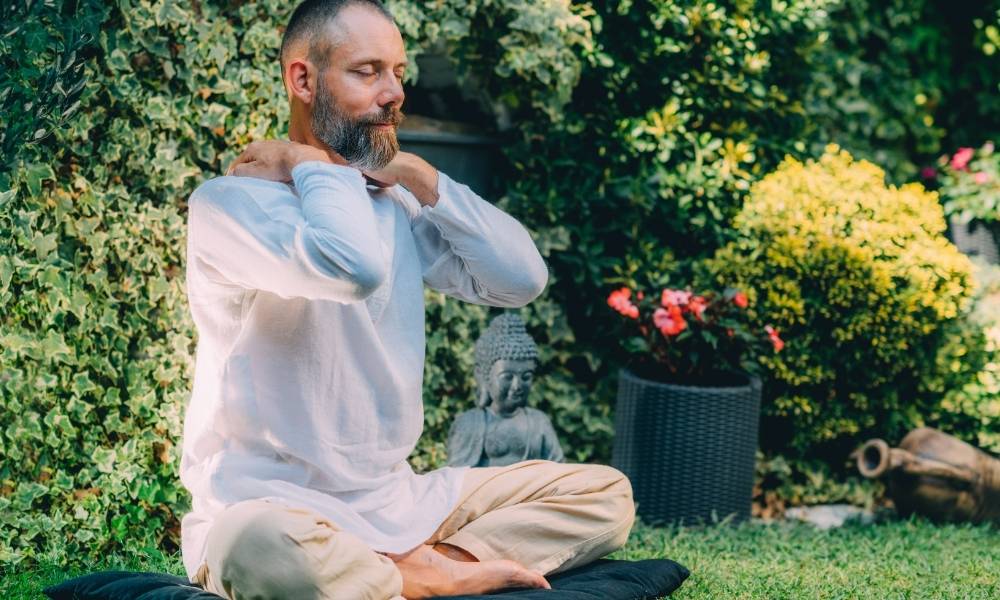 a man sitting outside cross legged meditating. Life path number 4